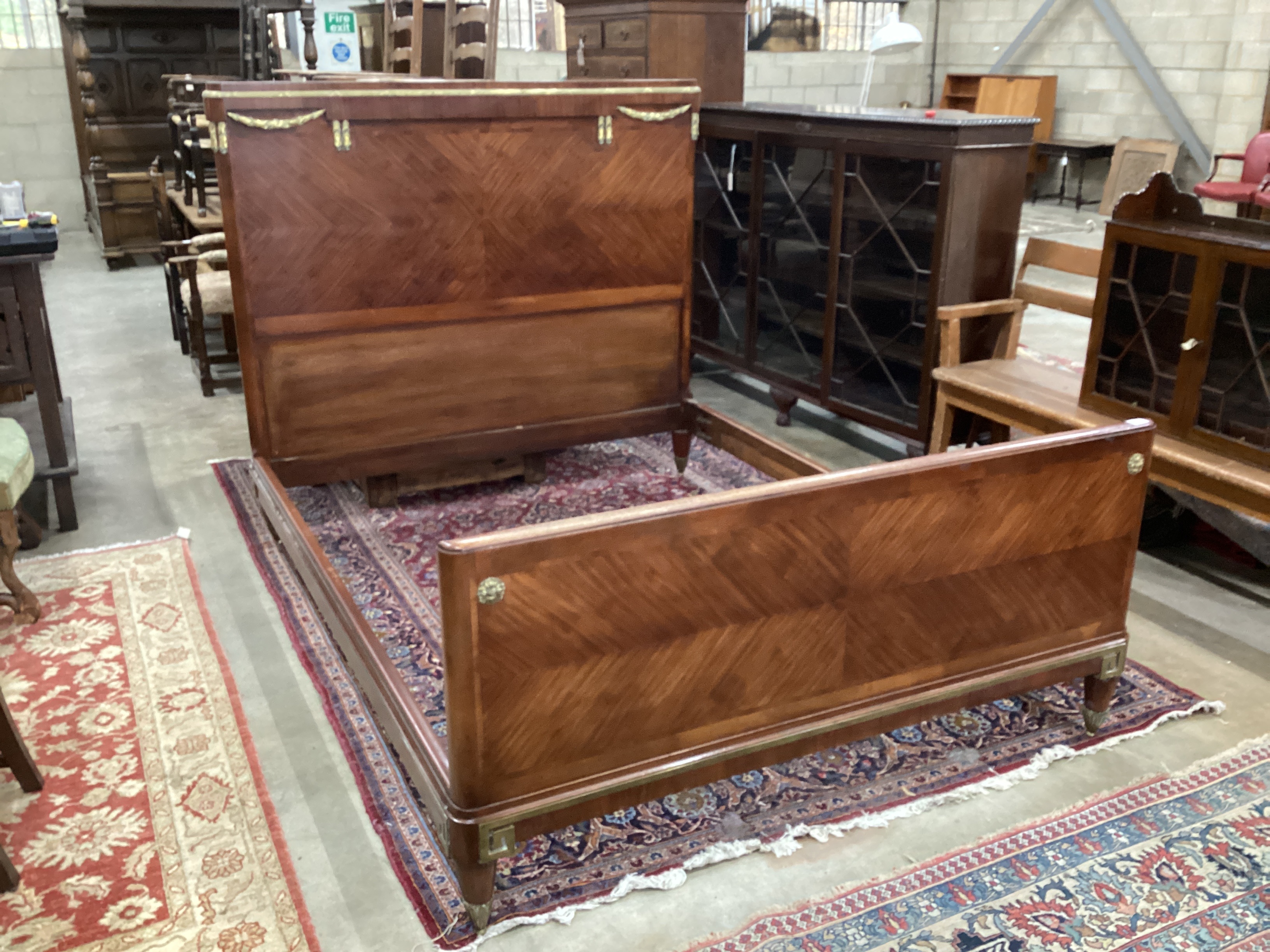 An early 20th century French walnut gilt metal mounted double bedframe, width 161cm, length 210cm, height 145cm